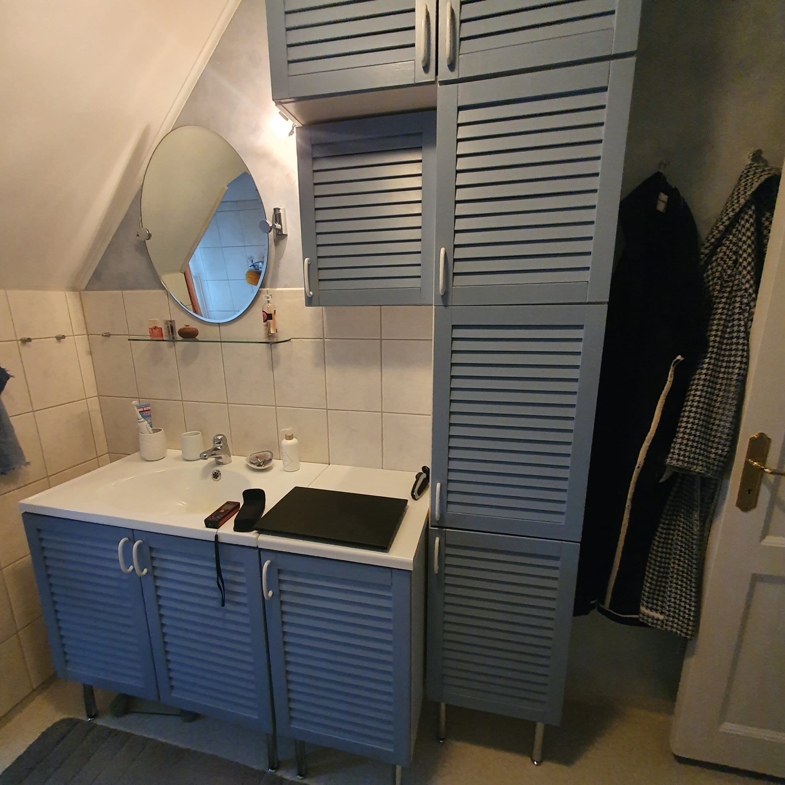 Helkaklat badrum med moderna materialval, duschhörna med vikbar glasvägg och vägghängd toalett.