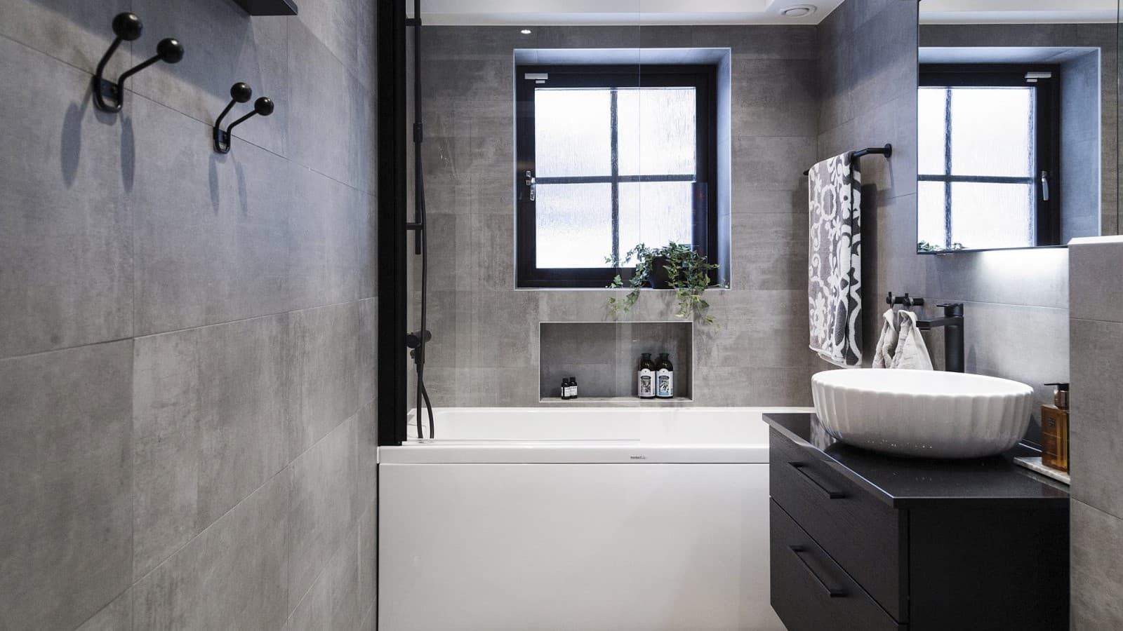 Modernt badrum med intrustriell känsla i grått och svart