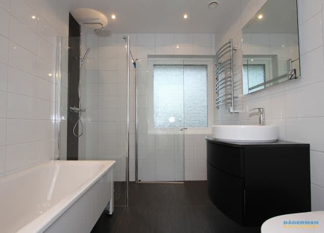 Ett vitt badrum med svarta detaljer